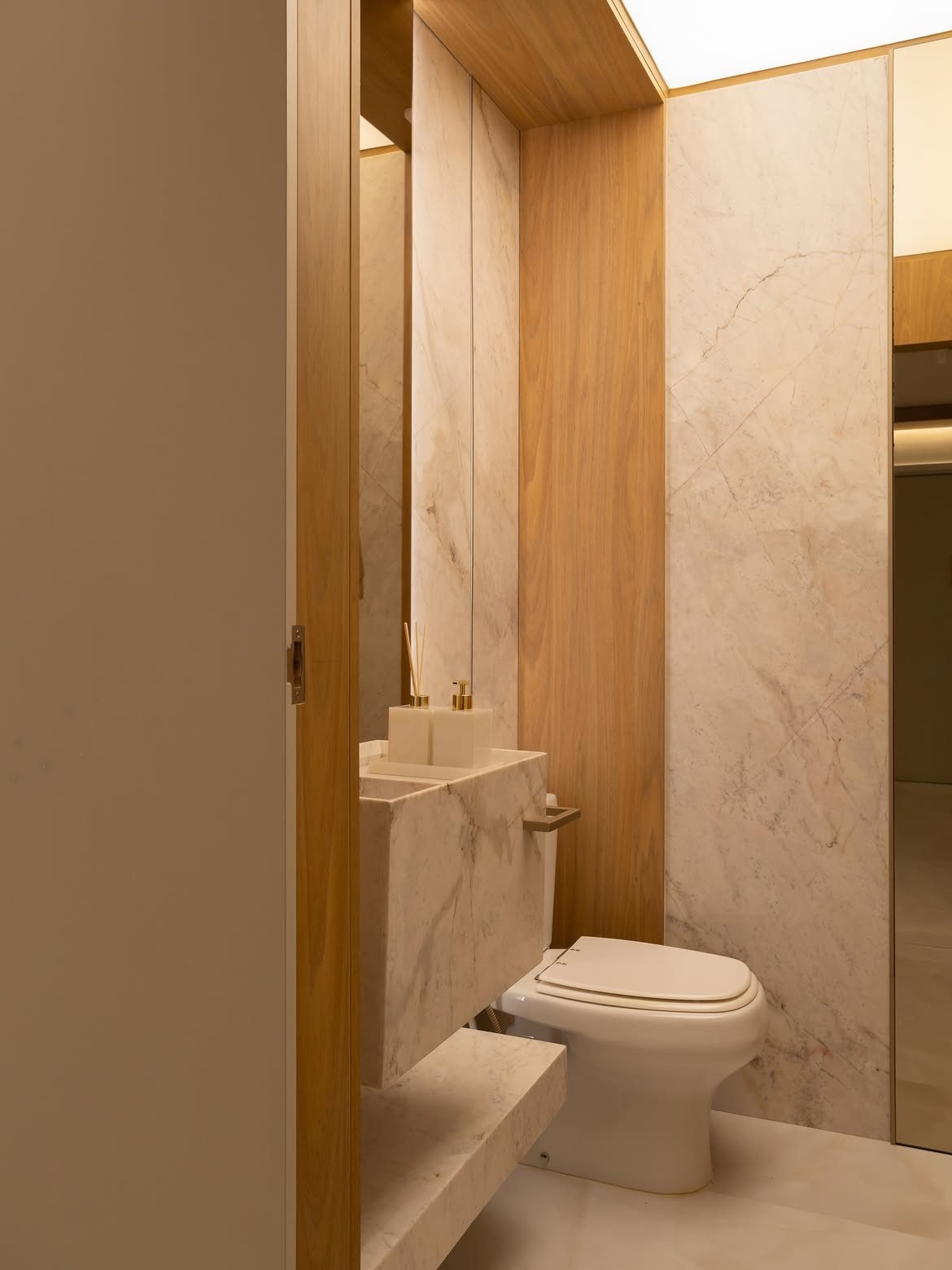 Lavabo revestido em mármore branco com bancada maciça