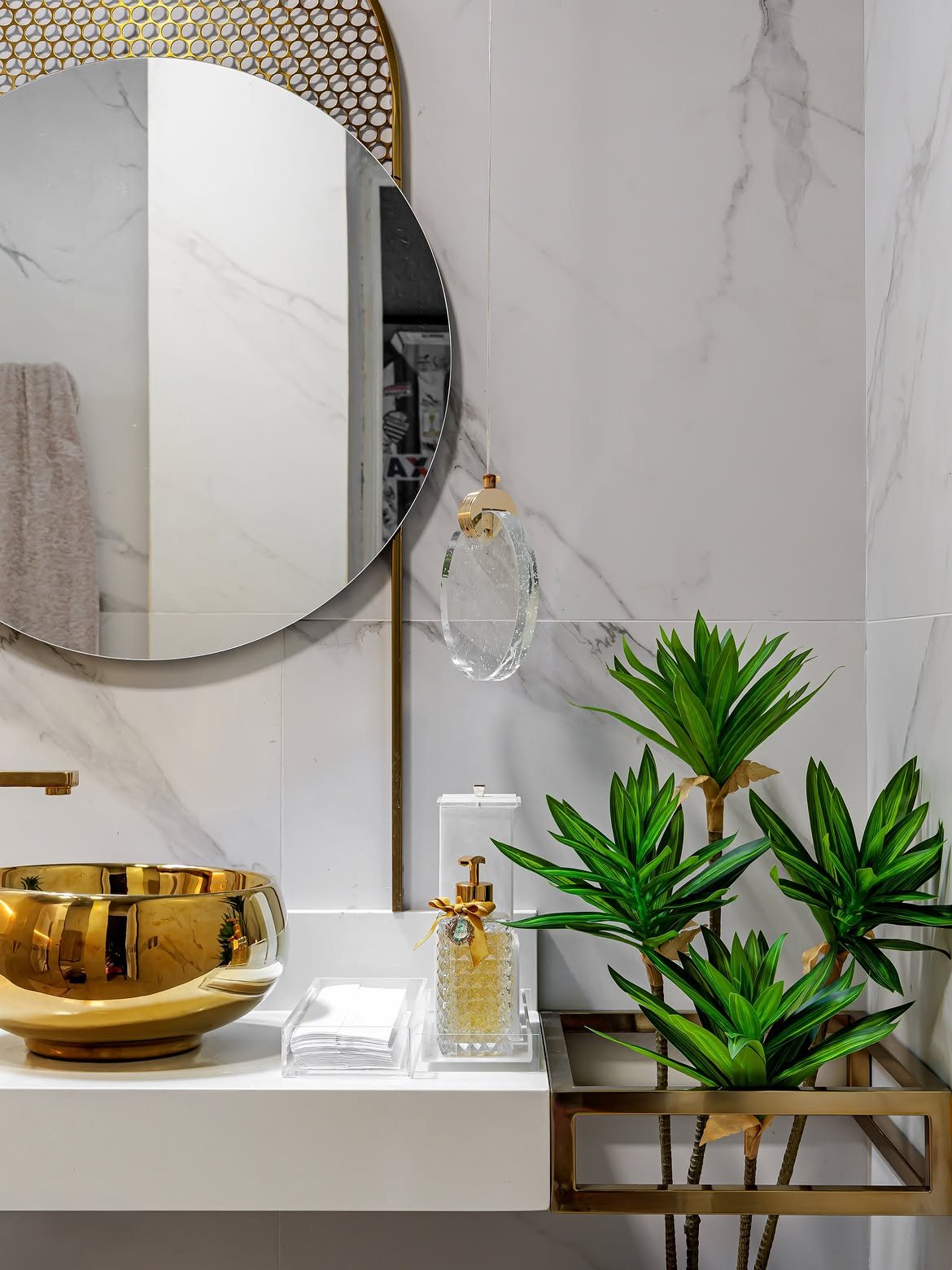 Lavabo com parede em lâmina Calacatta e cuba dourada