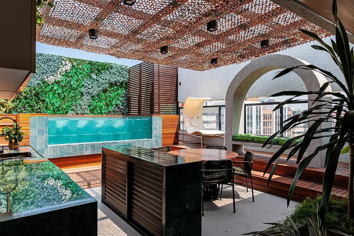 Terraço com bancada em mármore verde e jardim vertical